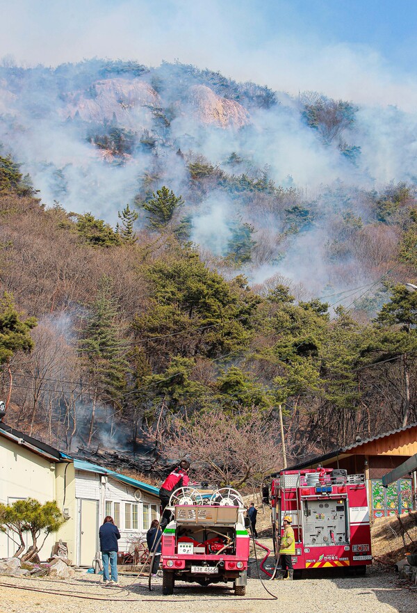 건조한 날씨가 이어진 18일 완주군 용진읍 일원 야산에서 산불이 발생하여 전북 소방 관계자들을 비롯한 산불진화팀들이 산불 진화를 하고 있다.
