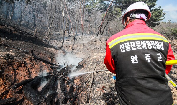 건조한 날씨가 이어진 18일 완주군 용진읍 일원 야산에서 산불이 발생한 가운데 완주군 산불전문예방진화대가 잔불 진화를 하고 있다.