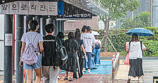 흐린 날씨와 함께 비가 오락가락 이어진 24일 전주역 앞에서 전주를 찾은 방문객들이 택시 탑승을 위해 임시 택시승강장으로 이동하고 있다.