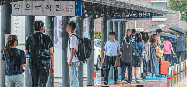  흐린 날씨와 함께 비가 오락가락 이어진 24일 전주역 앞에서 전주를 찾은 방문객들이 택시 탑승을 위해 임시 택시승강장으로 이동하고 있다.