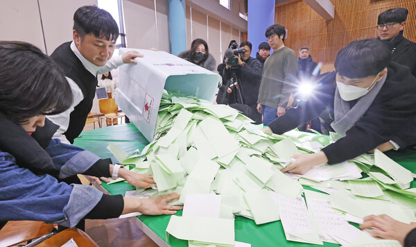 제22대 국회의원선거 수검표 시연이 진행된 24일 전주대학교 스타센터에서 전북특별자치도 선거관리위원회 관계자들과 관련 공무원들이 개표 시연할 투표 용지들을 쏟아붓고 있다.
