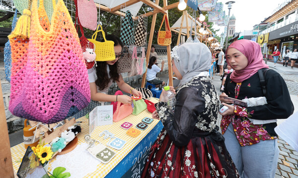 2024 제3회 무형유산 이음축제가 열린 28일 전주 경기전 돌담길에 마련된 무형유산 프리마켓에서 외국인 여성들이 수공예품을 구입하고 있다./이원철기자